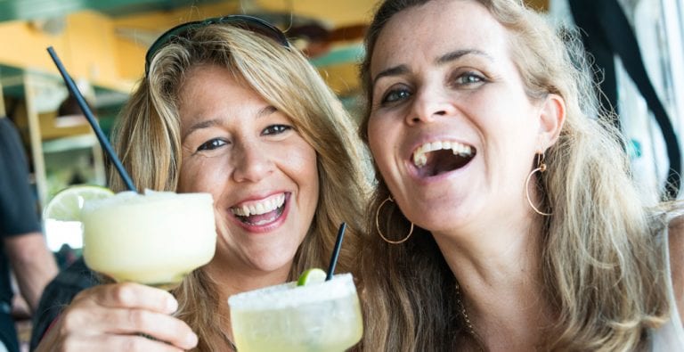 two women enjoying cocktail from Cincinnati cabana bar