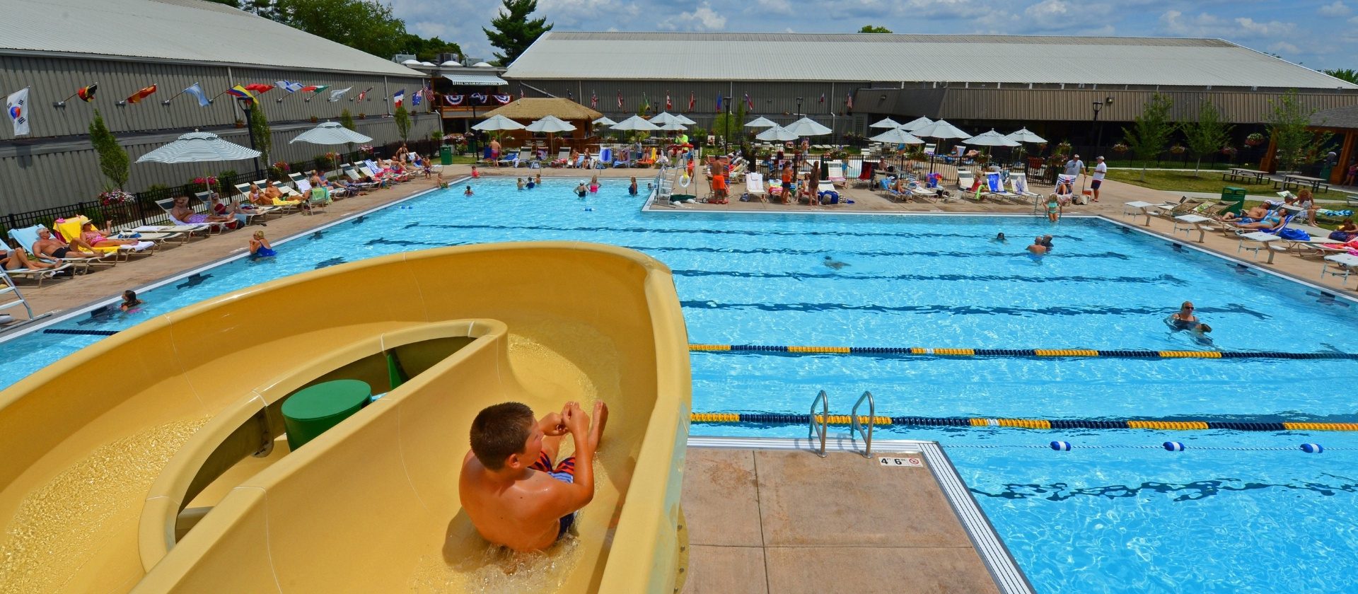 a kid slides into the pool at a fitness center and swim club near me in cincinnati