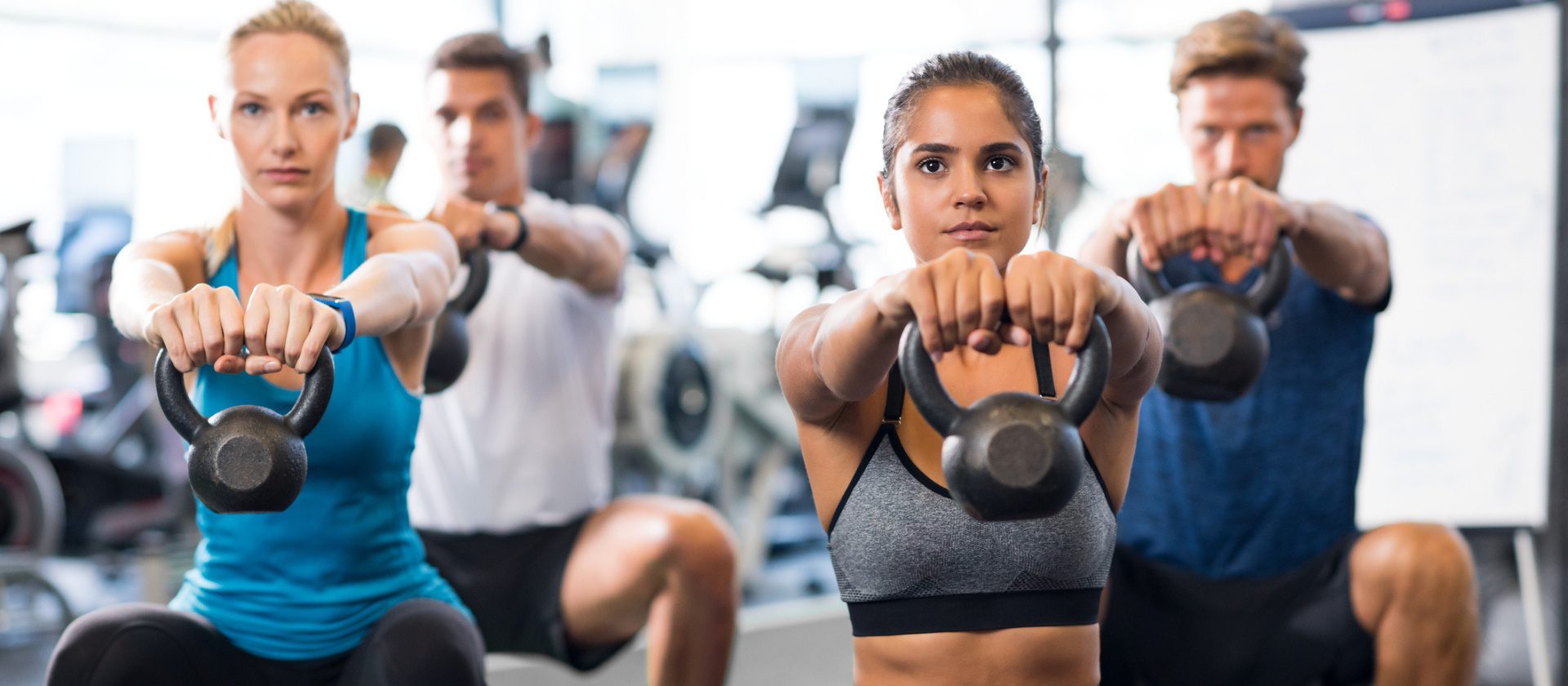 gym members use kettlebells during a group strength exercise at the club at harpers point fitness center