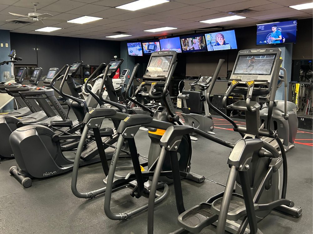 a row of elliptical cardio training machines at the club at harpers point gym in cincinnati