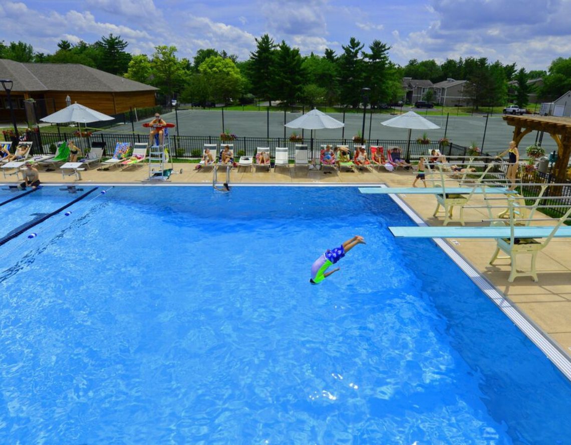 a club member dives into the outdoor pool at the club at harpers point aquatic center in cincinnati